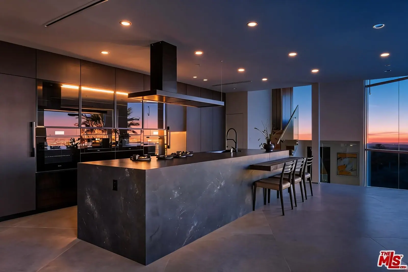 Chef kitchen with marble island and dark cabinetry
