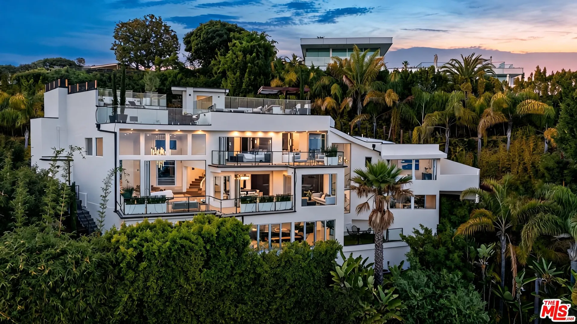 Modern Hollywood Hills estate with illuminated pool at dusk