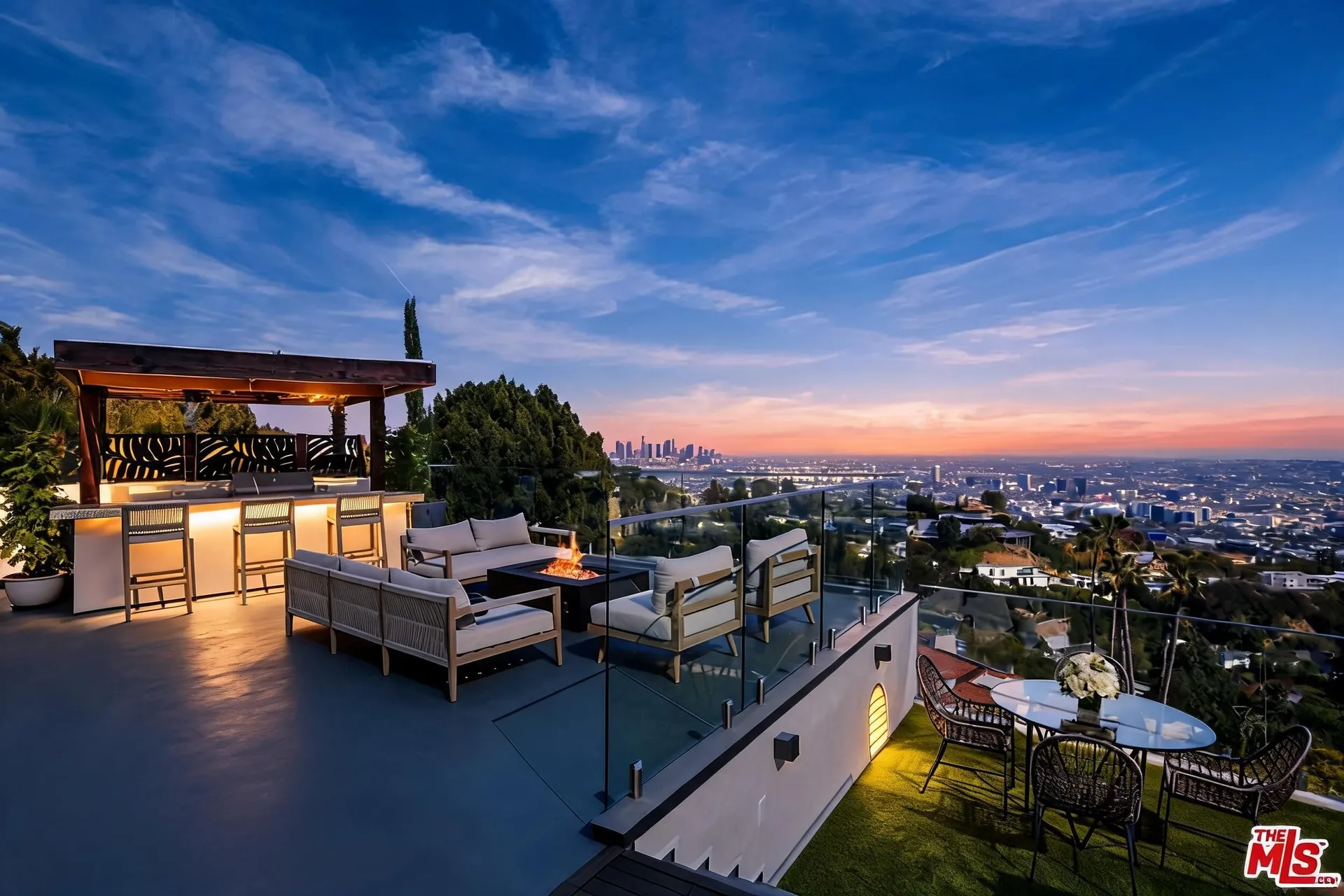 Rooftop terrace with pergola bar, lounge seating, fire pit and downtown skyline
